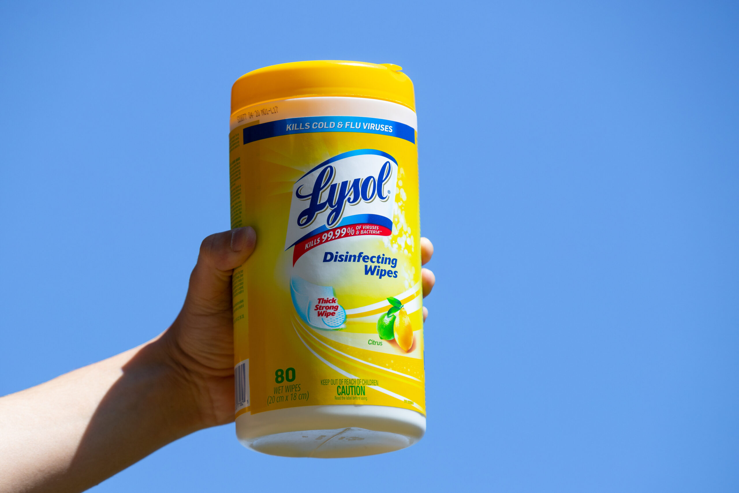 Hand holding a container of Lysol Wipes