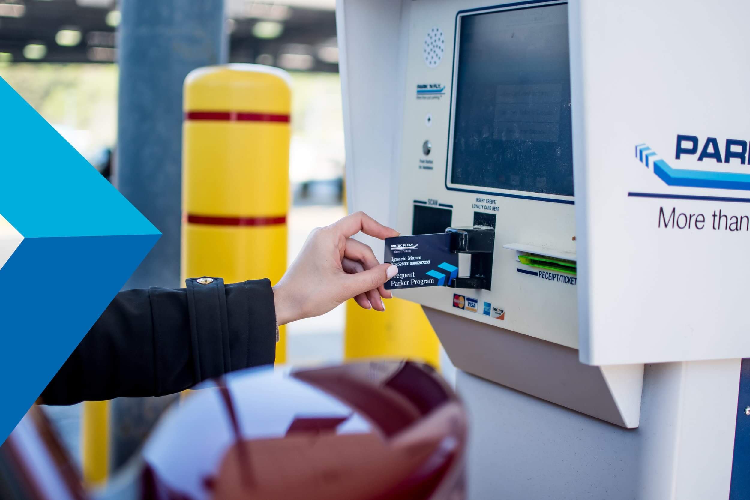 A credit card is being inserted into an outdoor kiosk to pay for parking.