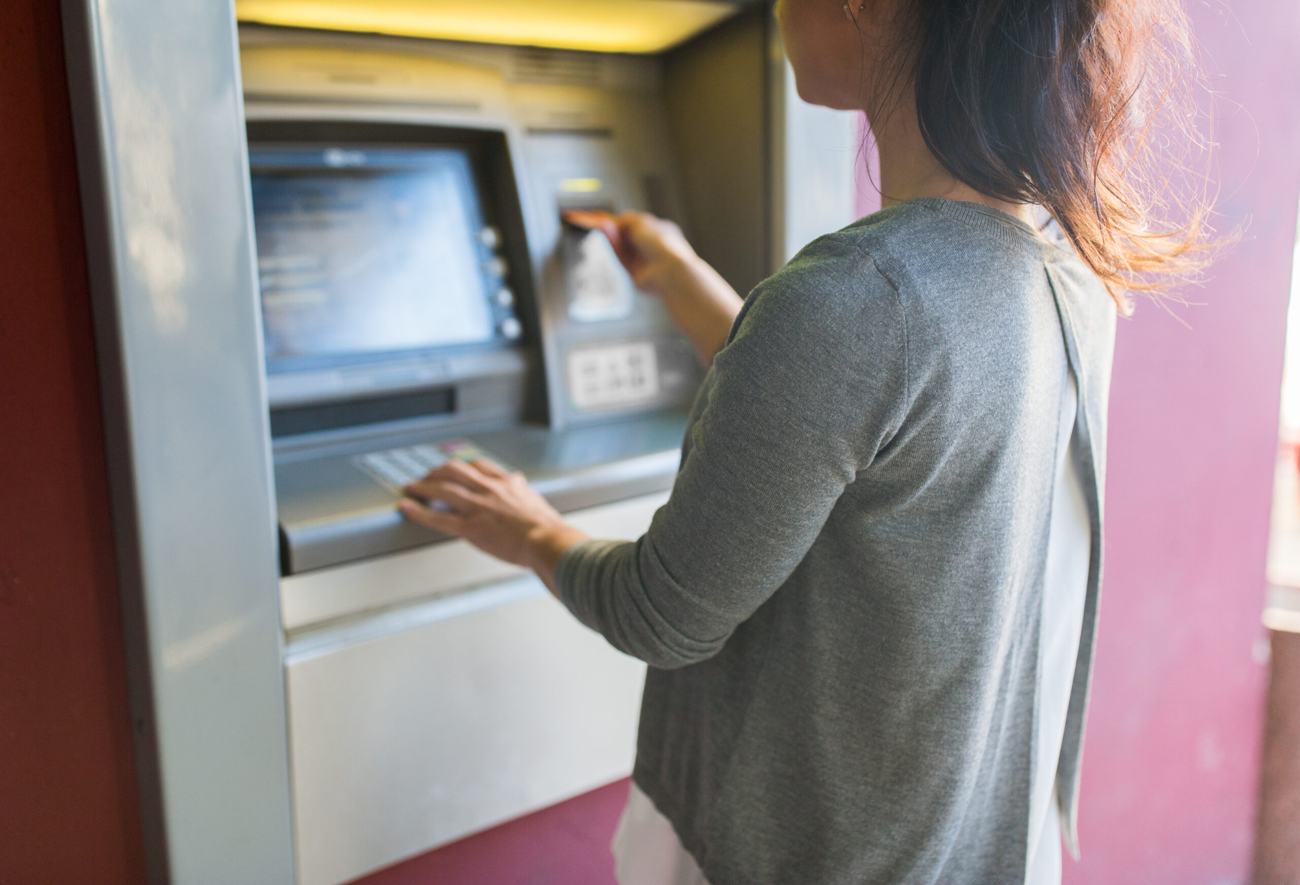 woman inserting card into an ATM