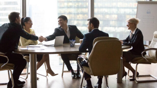 Smiling multiracial business people sitting at meeting in a bright office room