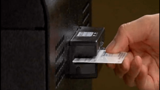 Up close of a hand threading a credit card through a digital card reader