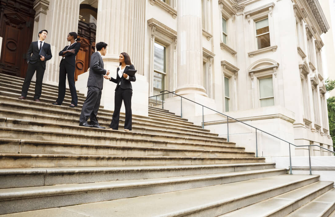 business people standing on the steps of a courthouse