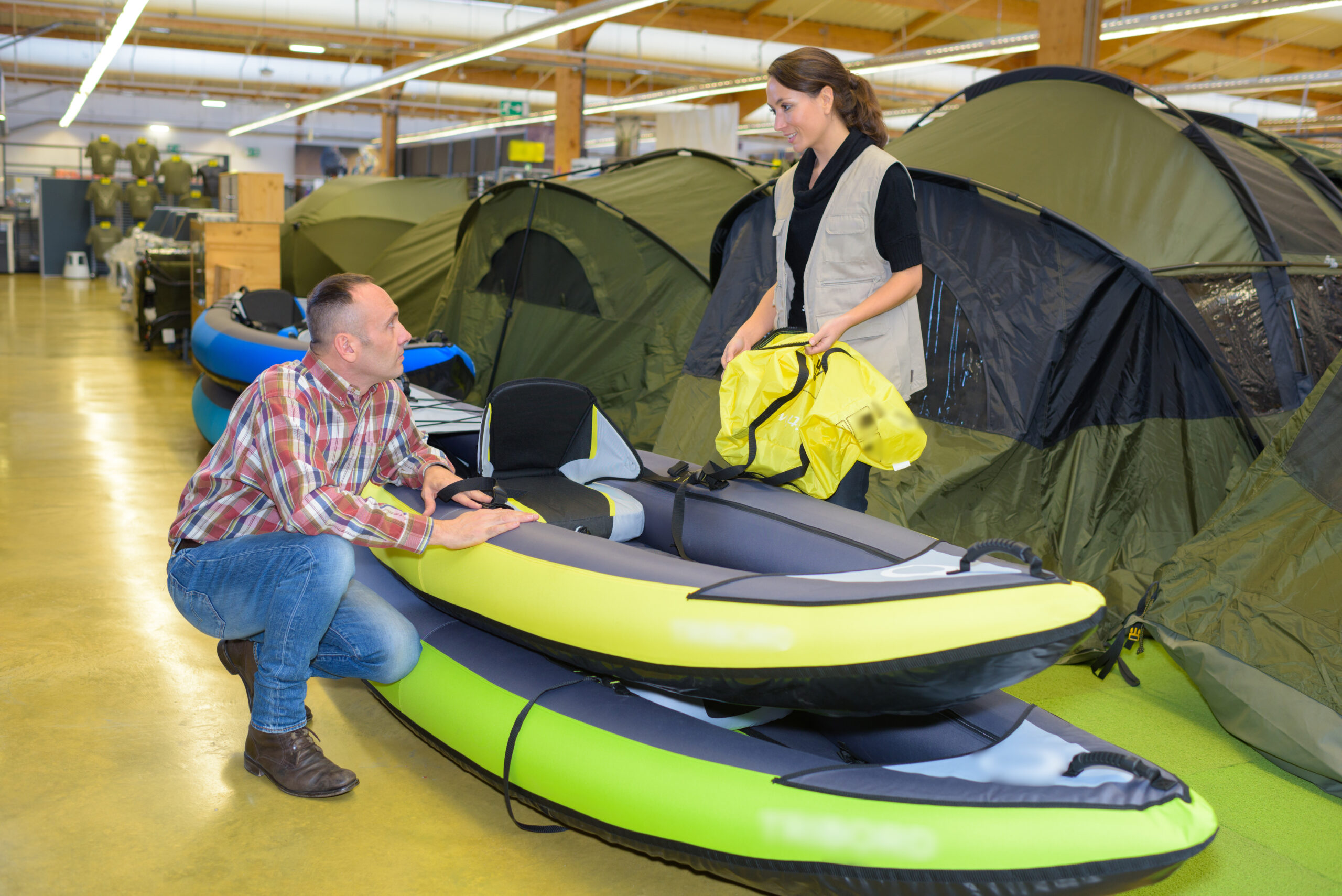 man looking at inflatable kayaks in sporting good store