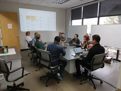 employees in a meetnig reviewing a calendar on a projector