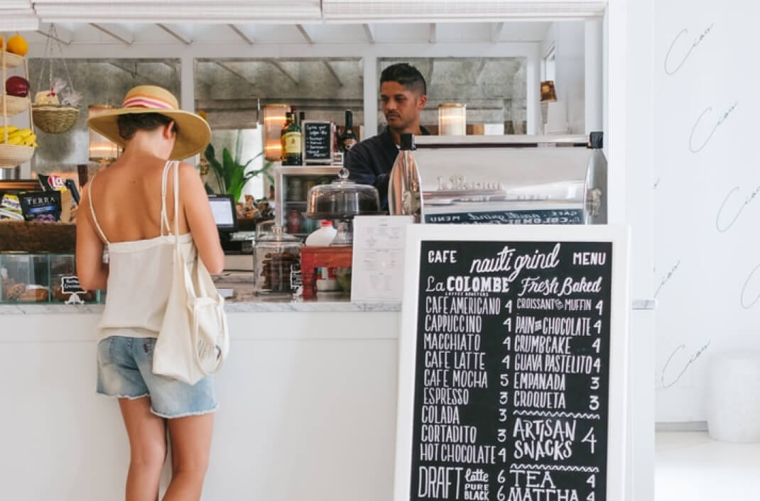 person ordering at the counter of a coffee shop