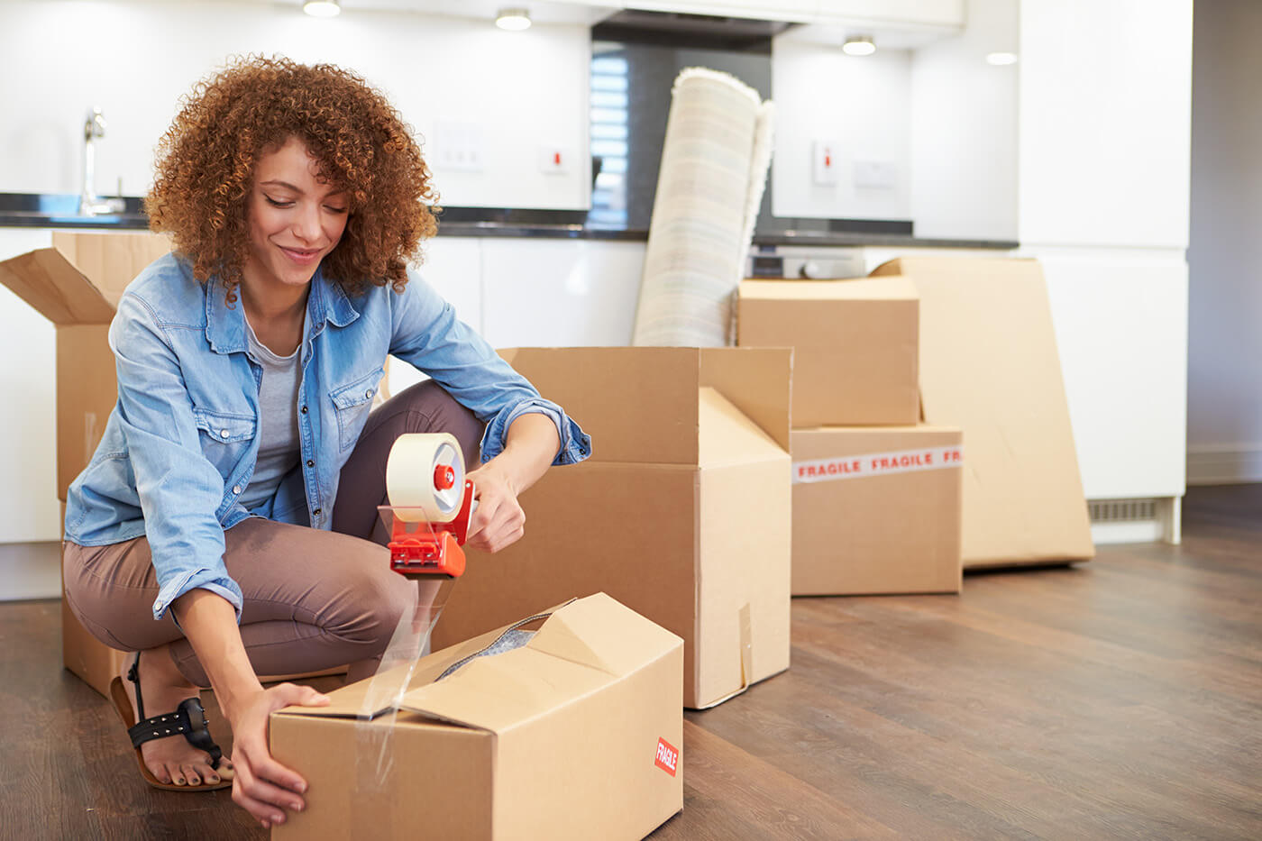 woman packing a box with packing tape