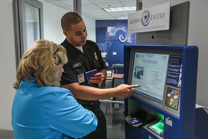 security agent showing woman how to use kiosk