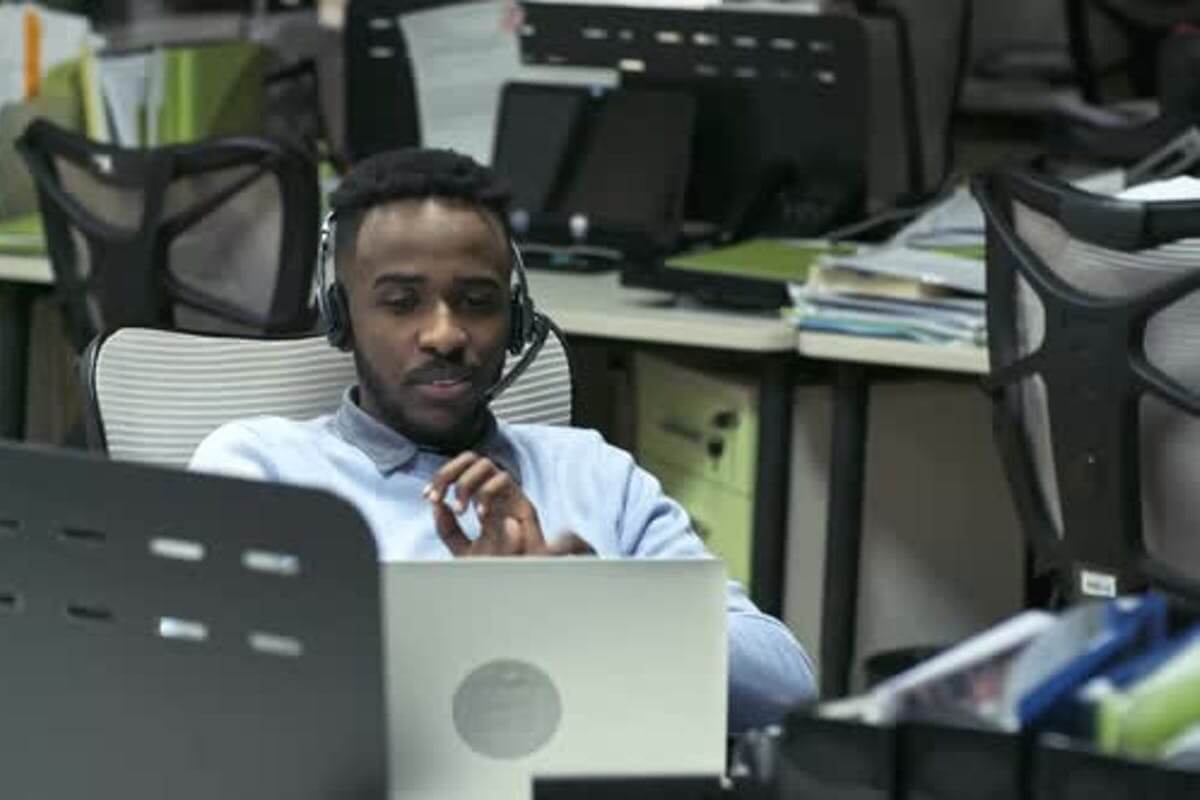 man talking on a headset while using laptop