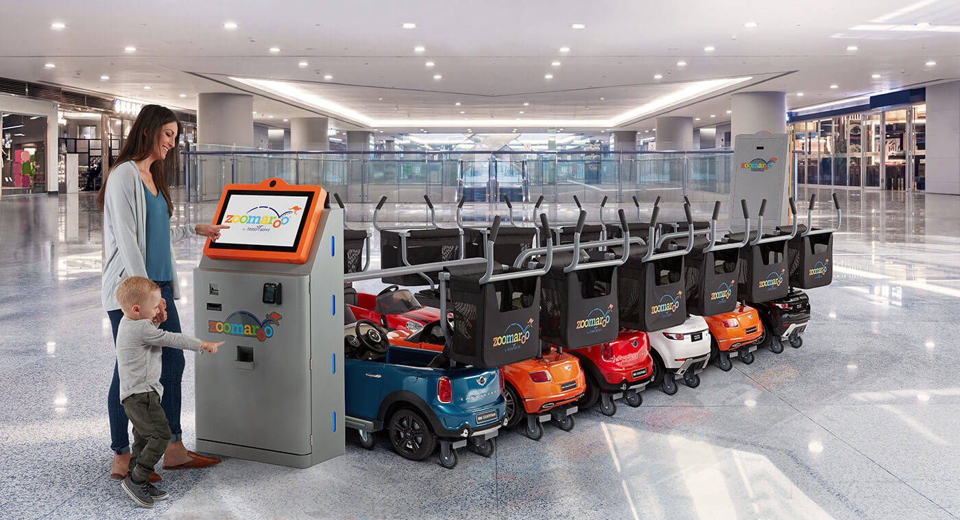 woman and son using zoomaroo stroller kiosk in mall