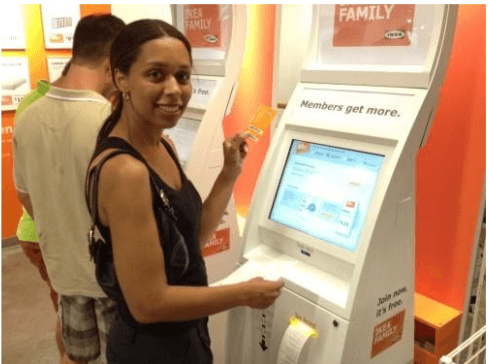 woman smiling while using a retail kiosk