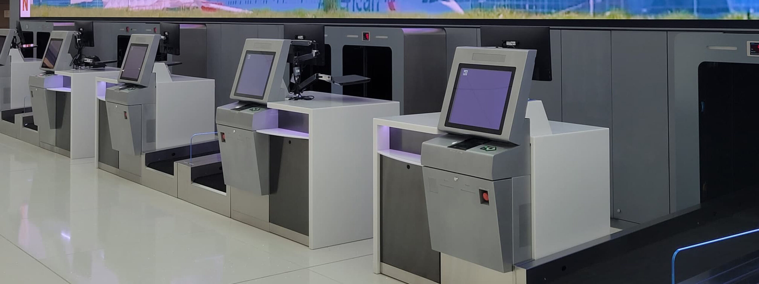 Airport lobby showcasing checkin / baggage drop-off kiosks
