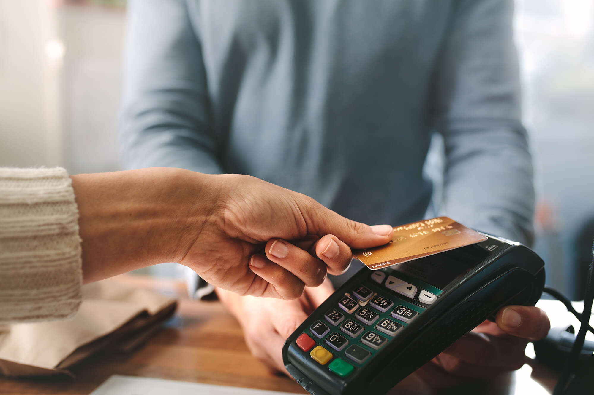 Shop keeper accepting credit card by contactless payment