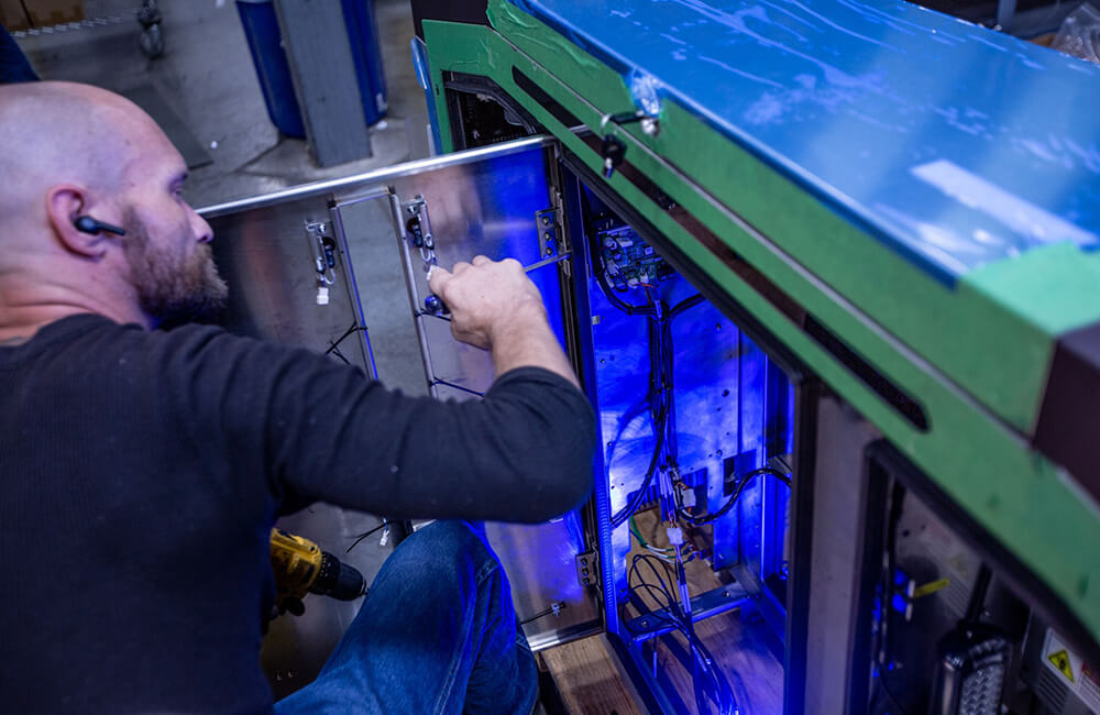 An employee performs maintenance on a self service kiosk