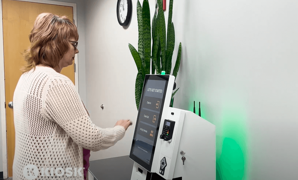A woman uses a hotel check-in kiosk.